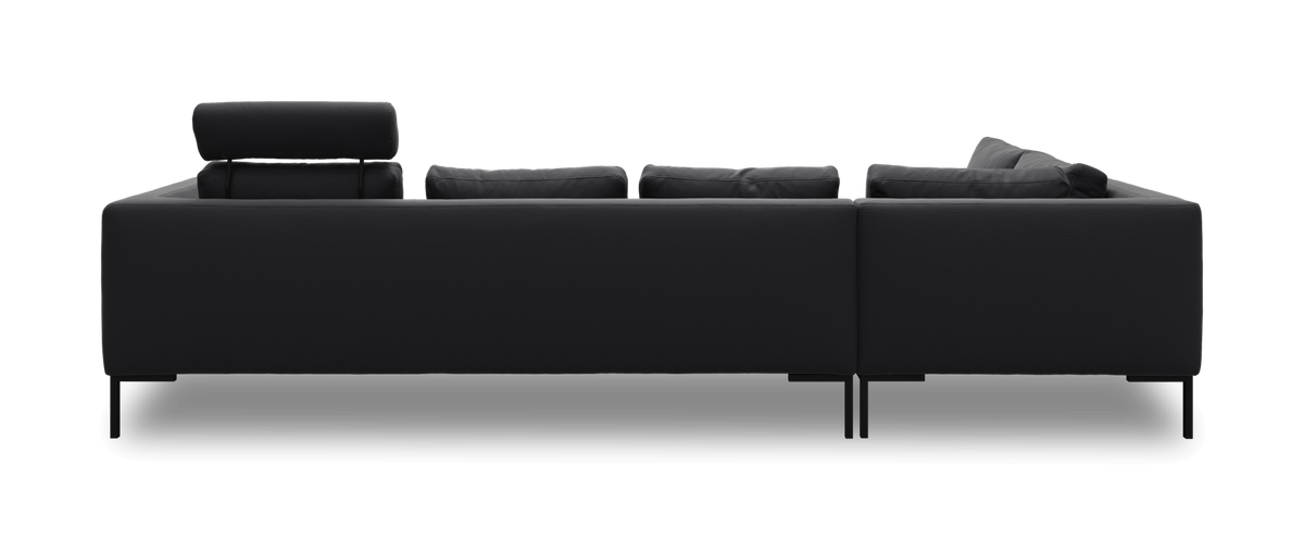 Bagside af en sort modulær L‑sofa med opklappet nakkestøtte i venstre side, slanke metalben, frilagt mod hvid baggrund.