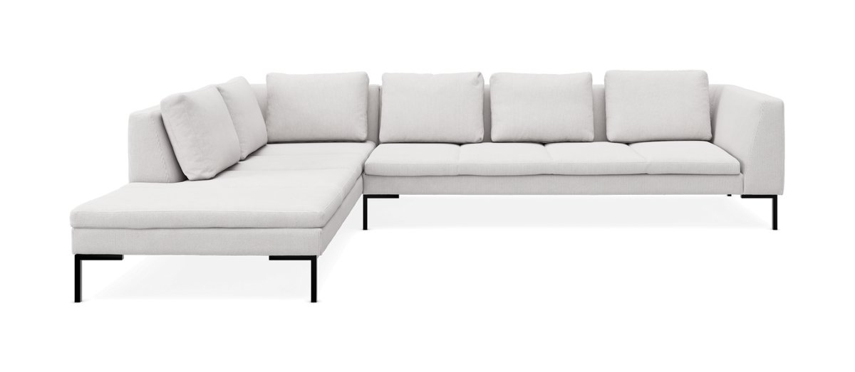 L‑formet hjørnesofa i lysegråt stof med slanke sorte ben på fritlagt baggrund.