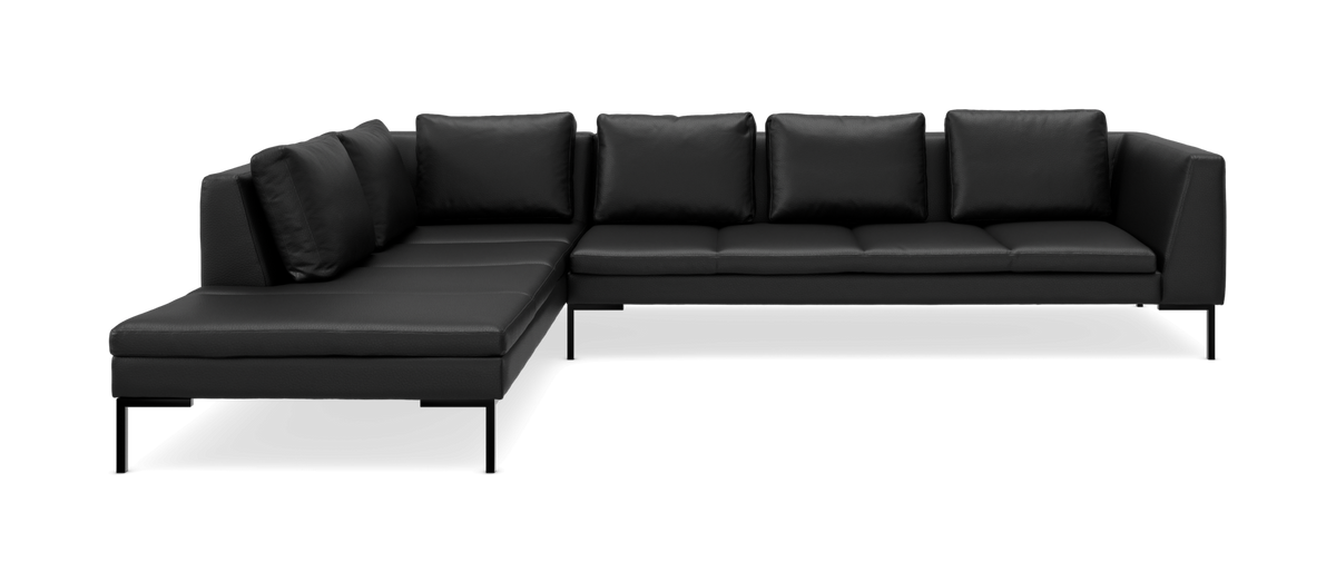 Sort L‑formet modulsofa med venstre chaiselong, slanke ben og løse ryghynder.