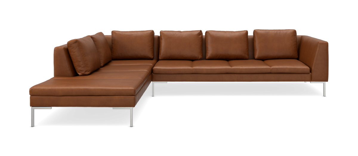 Modulær L-sofa i brun læder med venstre chaiselong og metalben, frilagt i studie.