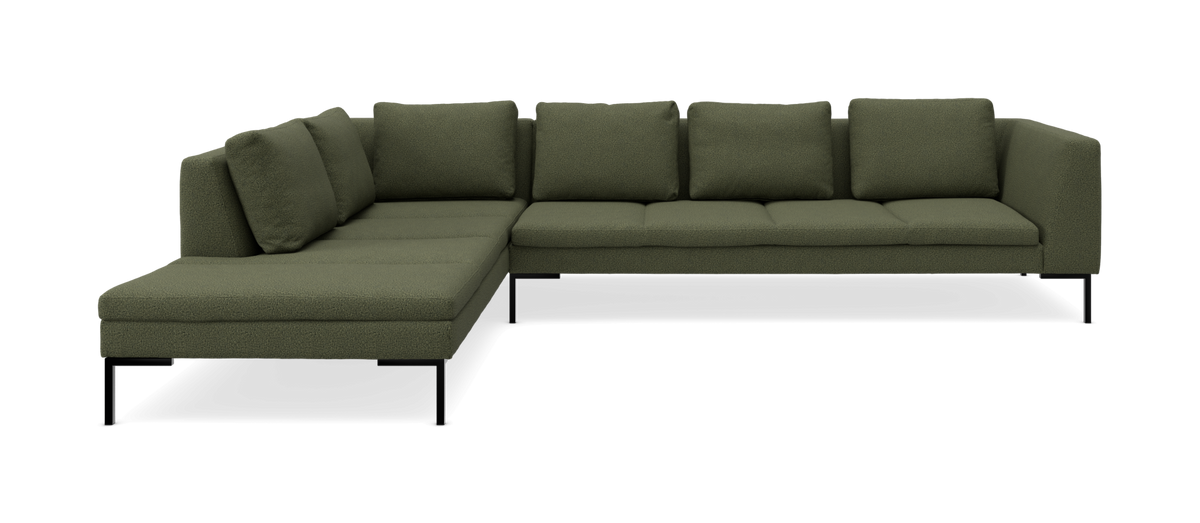 Grøn modulsofa i L-form med chaiselong til venstre og sorte metalben.