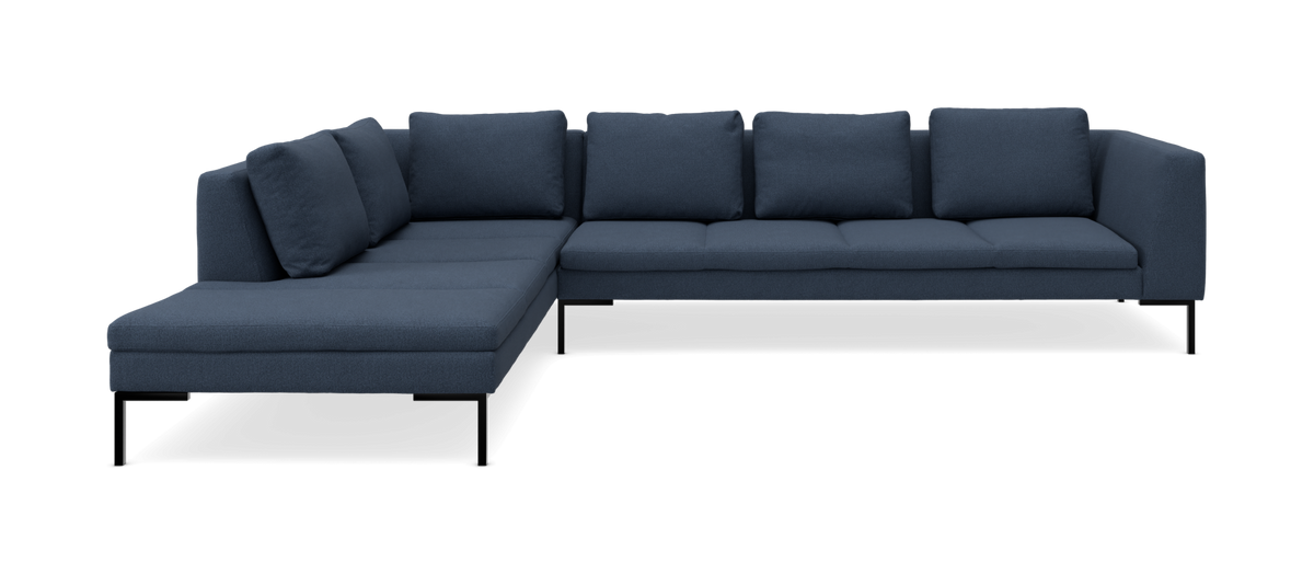Mørkeblå L‑formet modulsofa med venstrevendt chaiselong på slanke sorte ben.