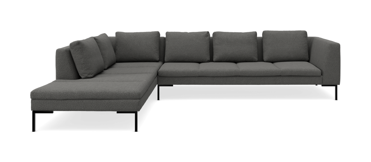 Mørkegrå hjørnesofa med venstrevendt chaiselong og slanke sorte ben, frilagt på neutral baggrund.