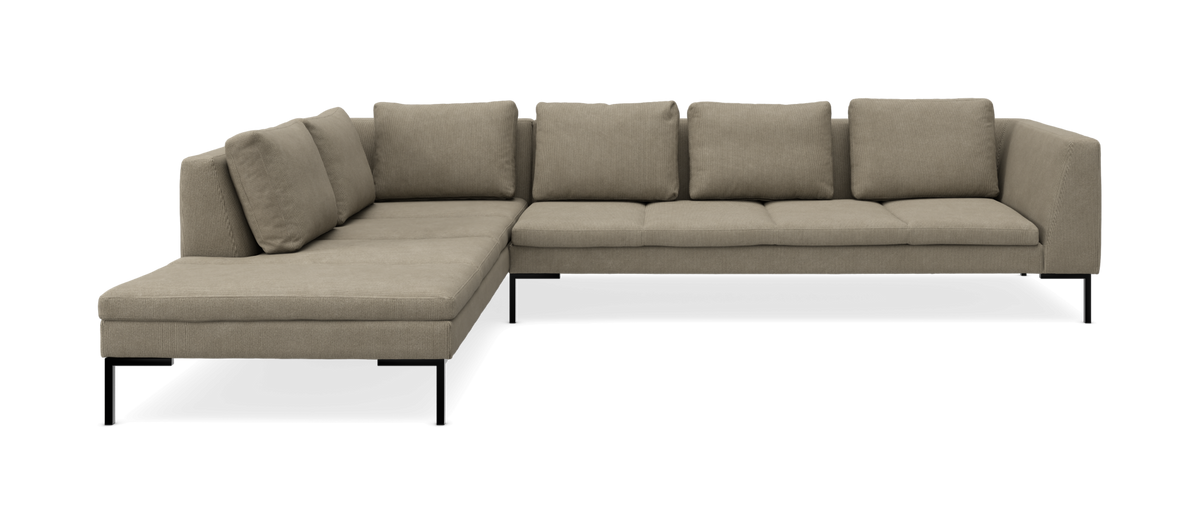 L‑formet modulsofa med chaiselong i beige stof og slanke sorte ben, fem ryghynder.