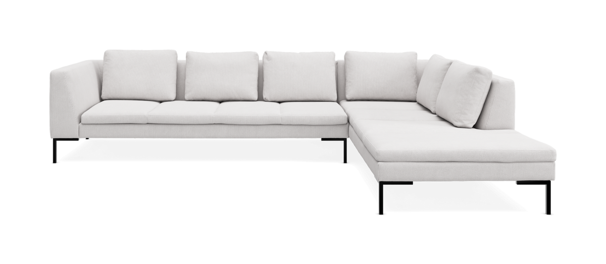 L‑formet lysegrå modulsofa med chaiselong til højre og slanke sorte ben, frilagt på hvid baggrund.