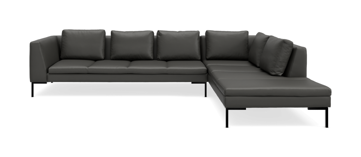 Mørkegrå L‑formet modulsofa med slanke sorte ben og løse ryghynder, frilagt på hvid baggrund.