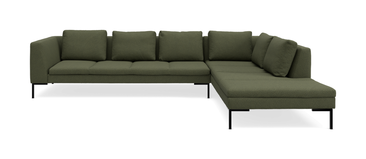 Olivengrøn L-formet modulsofa med chaiselong til højre, slanke sorte ben og løse ryghynder.
