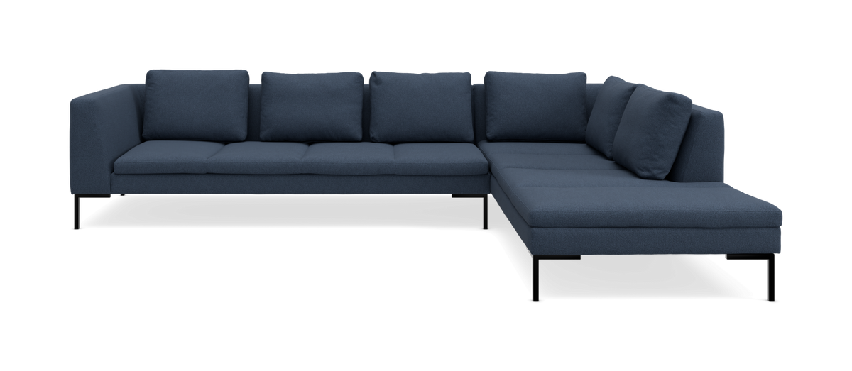 Mørkeblå L-formet modulsofa med slanke sorte metalben, set lige forfra.