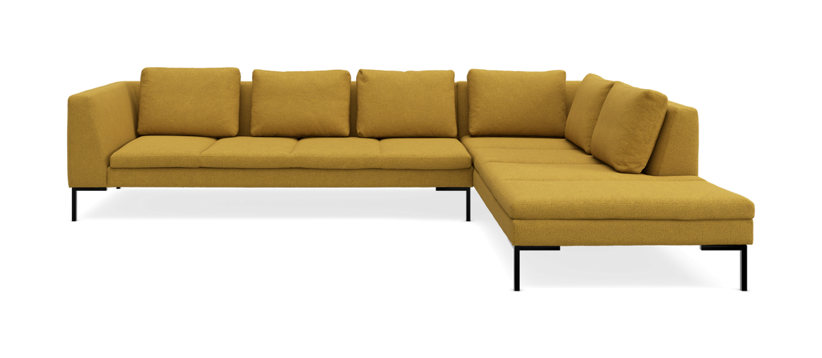 Gul hjørnesofa i stof med højrevendt chaiselong og metalben, frilagt.