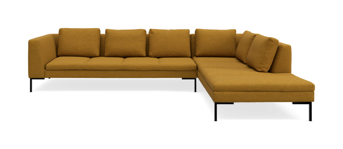 Sennepsgul L-formet hjørnesofa med chaiselong til højre og slanke metalben.