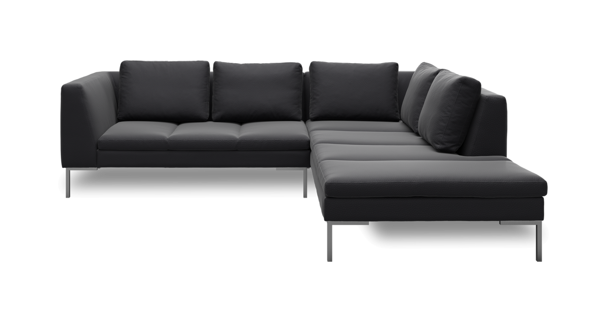 Mørkegrå L‑sofa med chaiselong til højre, løse ryghynder og slanke metalben.