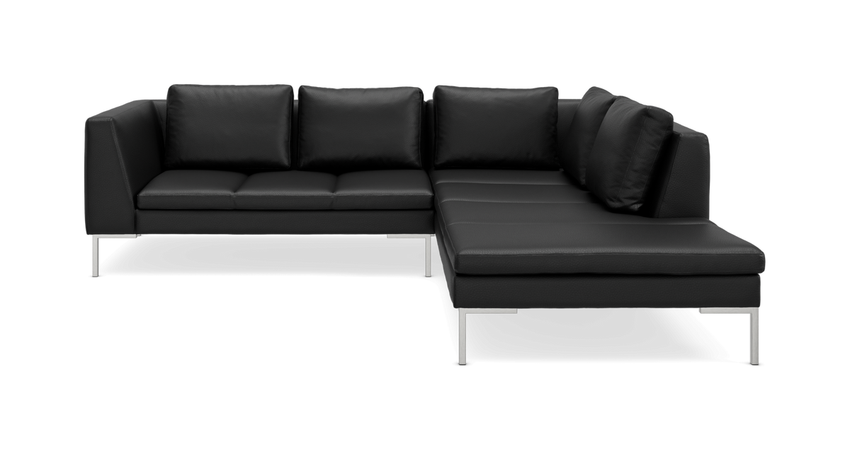 Sort L‑formet modulsofa med metalben og løse ryghynder.