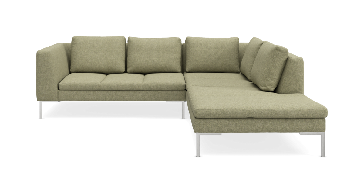 L-formet sofa i salviegrønt stof med chaiselong til højre og metalben, frilagt på hvid baggrund.