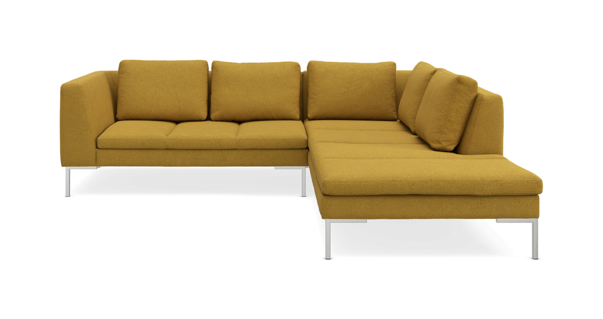 Sennepsgul L-formet modulsofa med chaiselong til højre og slanke metalben.