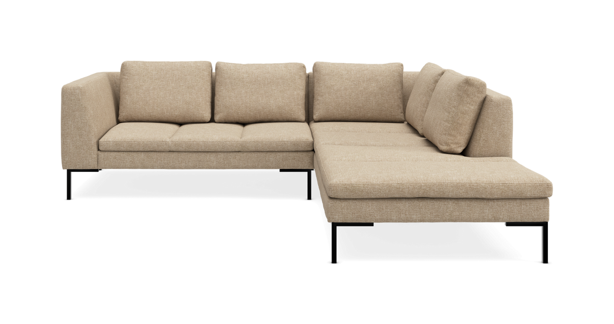 Beige hjørnesofa med chaiselong til højre på slanke sorte ben.