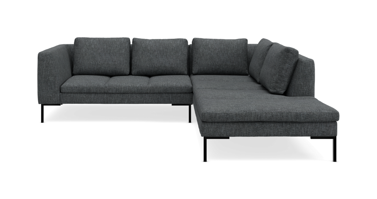 Mørkegrå L-formet modulsofa med chaiselong til højre og metalben på studiebaggrund.