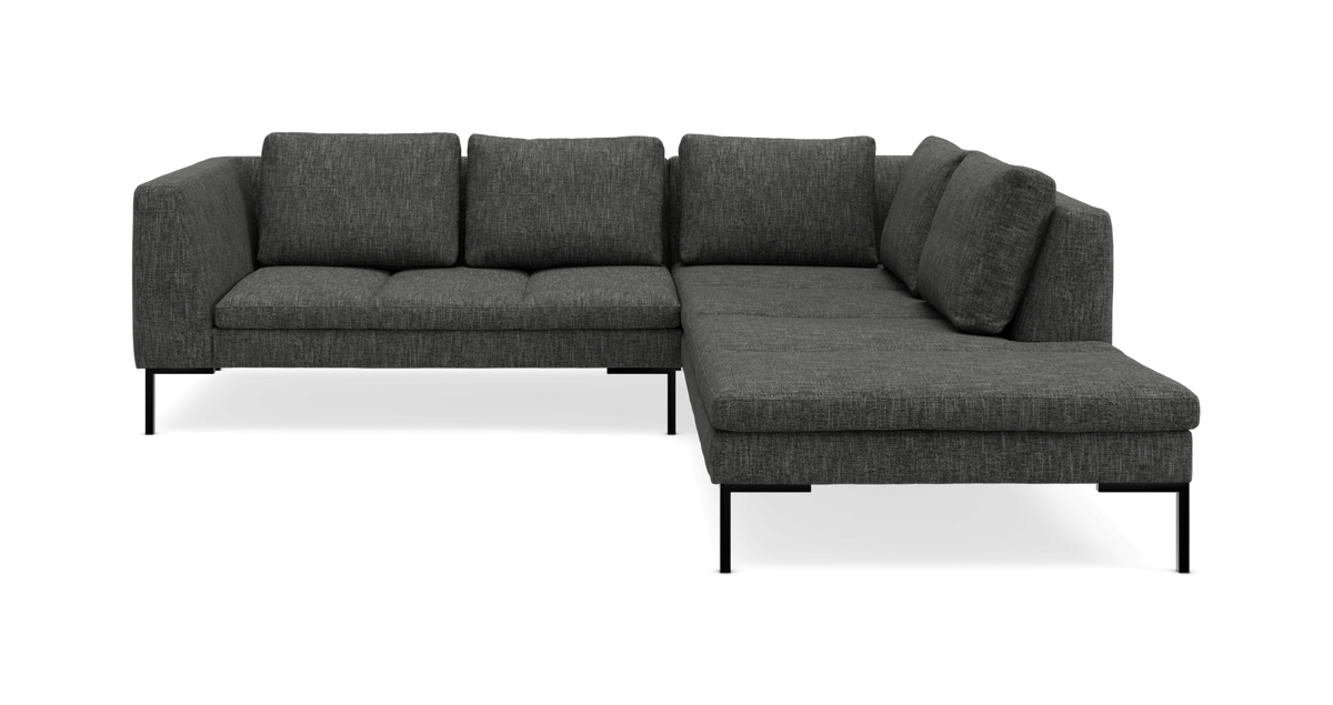 Mørkegrå L‑formet hjørnesofa med chaiselong til højre og slanke sorte ben.