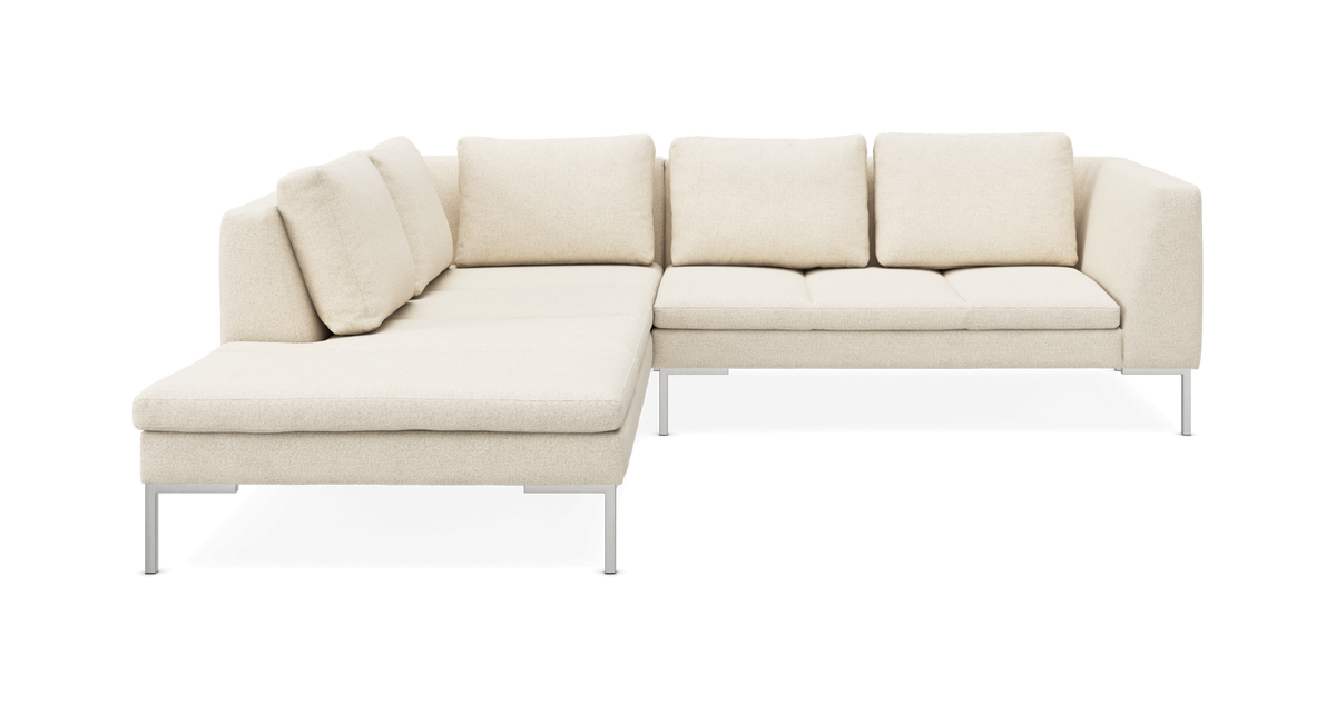 L-formet beige sofa med venstrevendt chaiselong, fire ryghynder og slanke metalben.