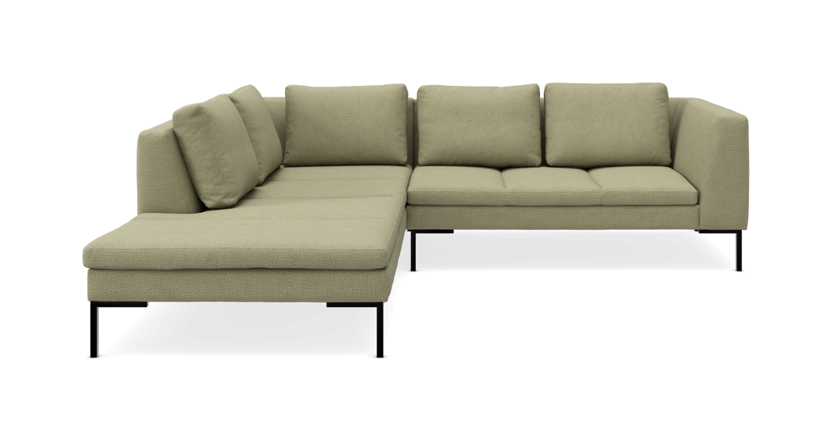 Grøn L‑formet modulsofa med chaiselong i stof og sorte ben, set forfra.