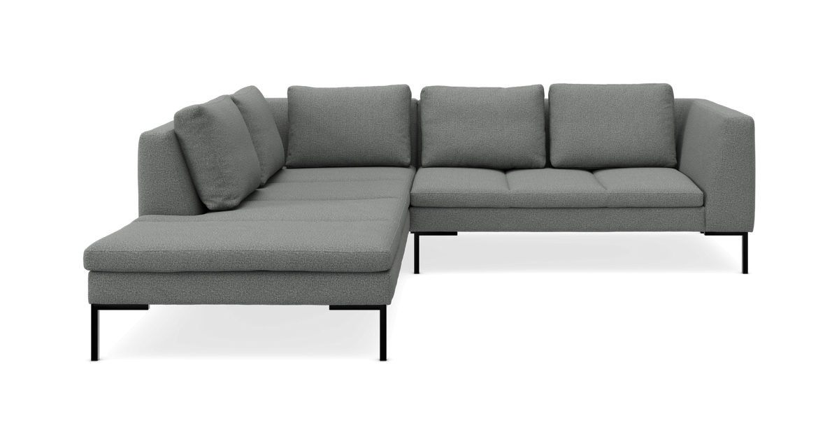 Grå L-formet modulsofa med slanke sorte ben og chaiselong til venstre.