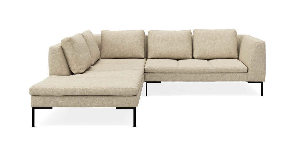 Beige L‑sofa med chaiselong til venstre og sorte ben, frilagt på hvid baggrund.