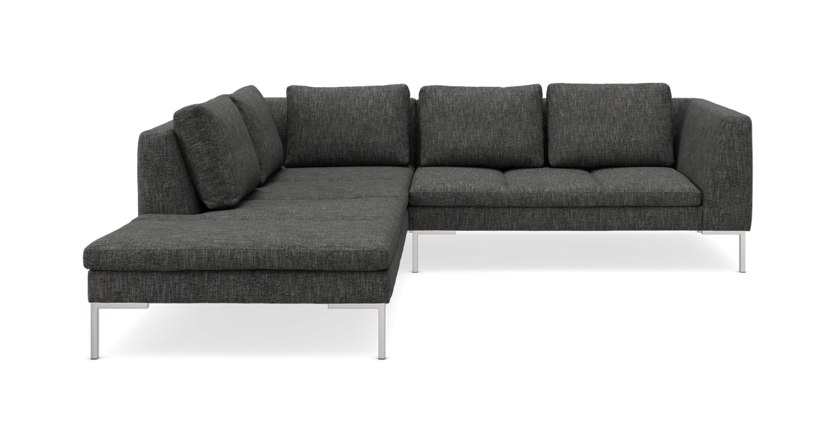 Mørkegrå L‑sofa med venstre chaiselong, stofbetræk og slanke metalben.