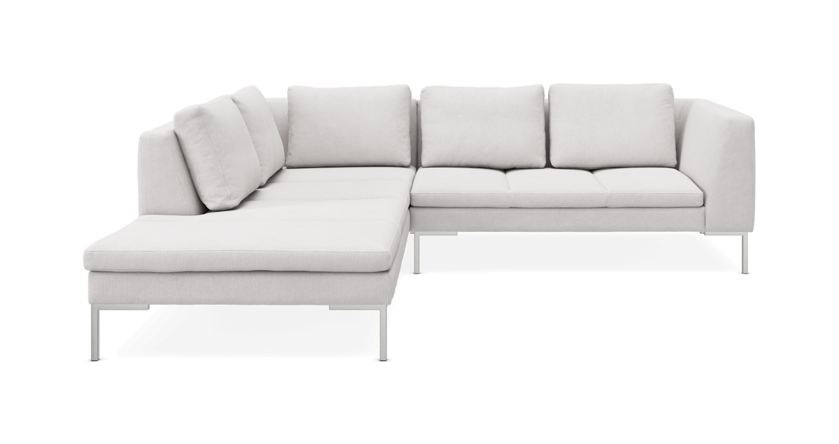 L-sofa i lysegråt stof med chaiselong til venstre og slanke metalben.