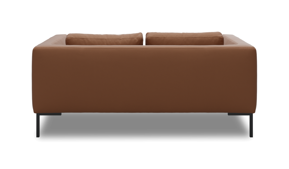 Bagside af en moderne brun lædersofa med slanke sorte metalben, frilagt på hvid baggrund.