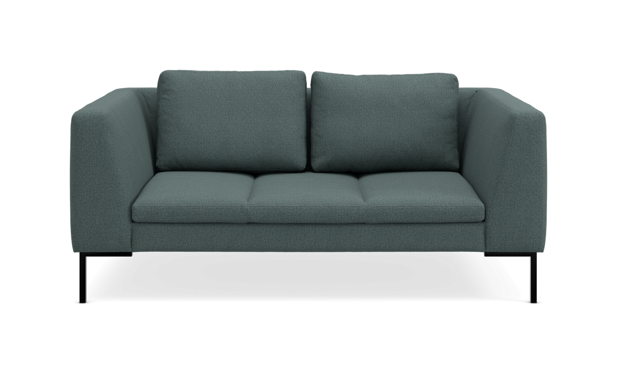 Moderne grøn sofa med slanke sorte metalben, frontvisning.