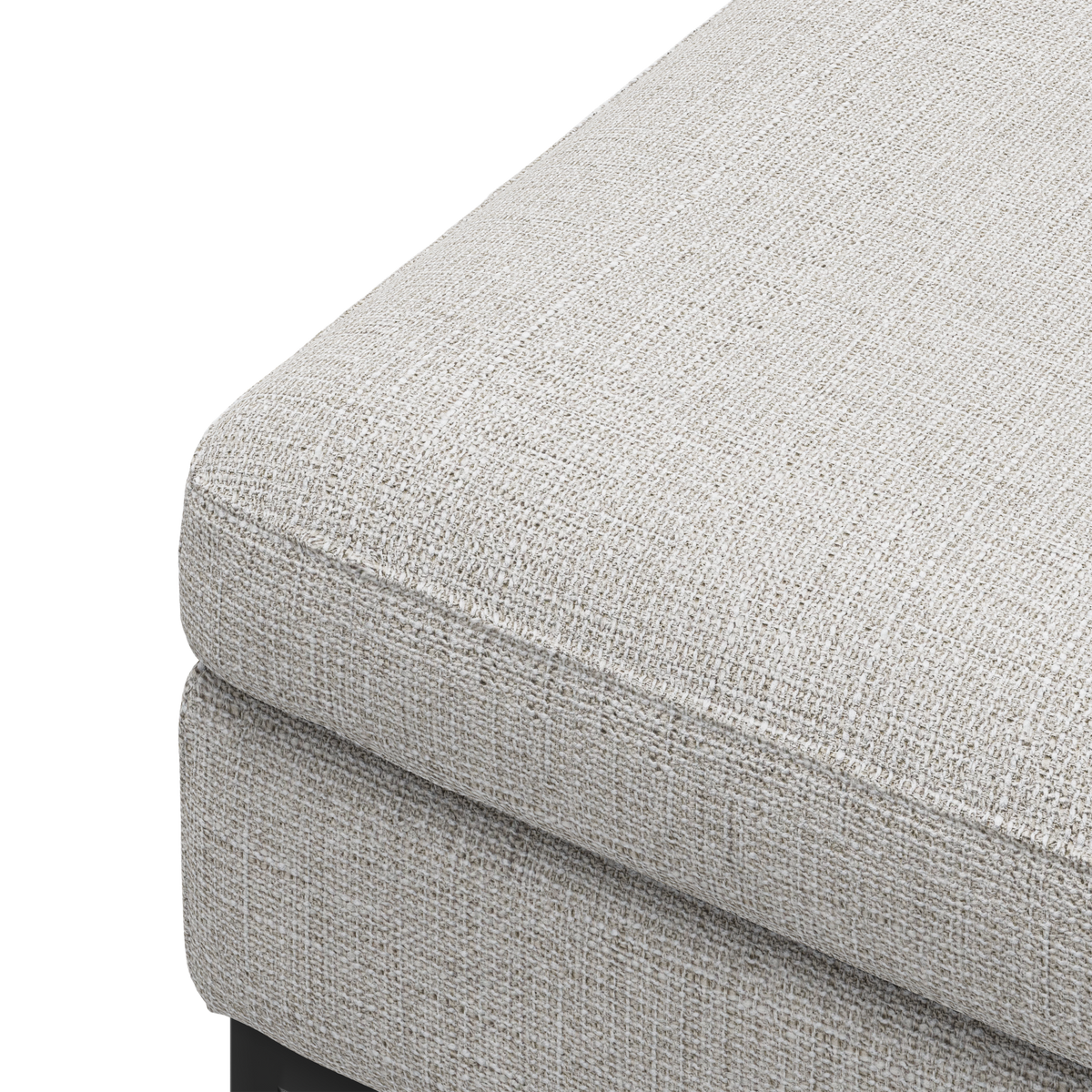 Nærbillede af hjørnet på en lysebeige, tekstureret stofhynde til sofa eller puf mod hvid baggrund.
