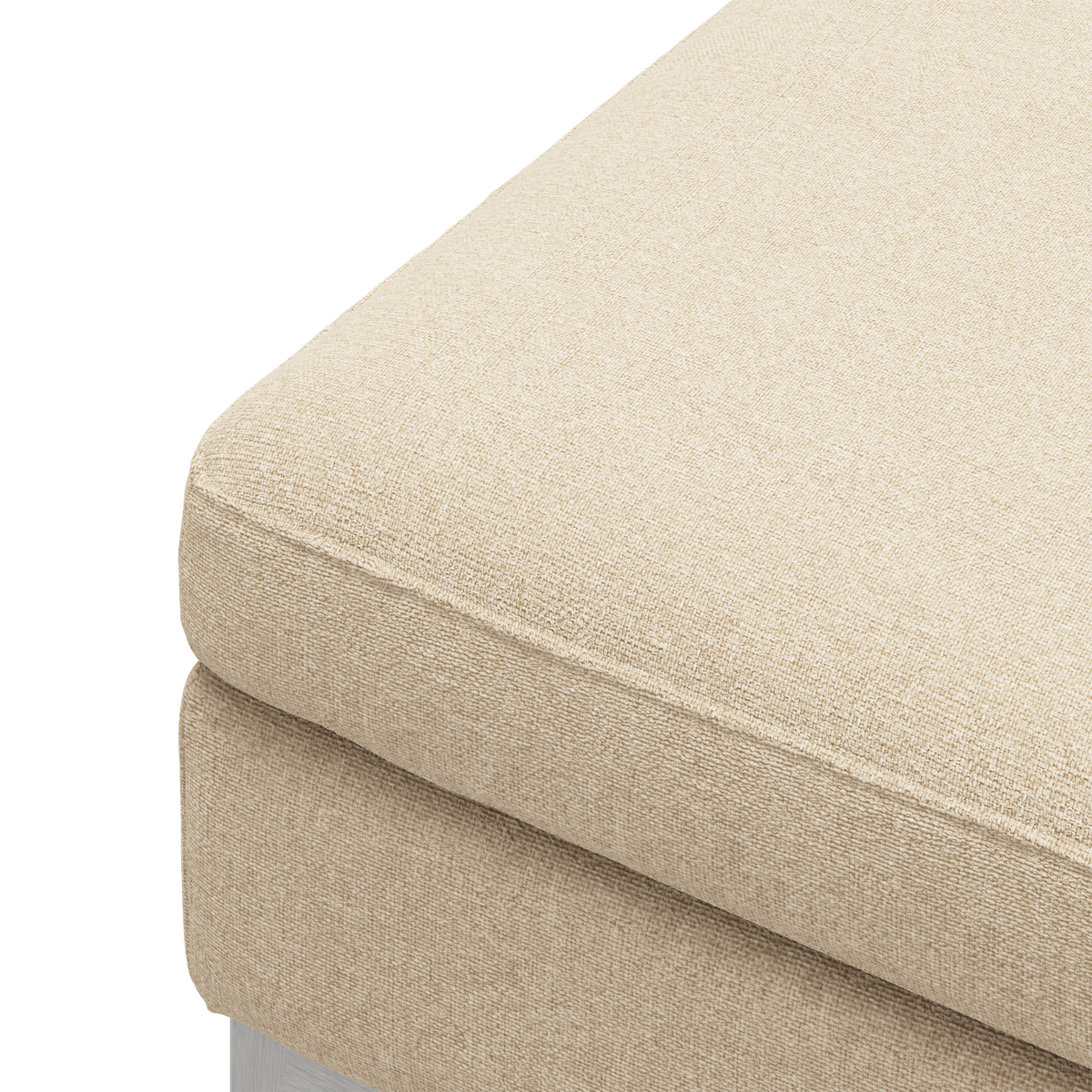 Nærbillede af hjørnet på en beige sofahynde i tekstureret stof.