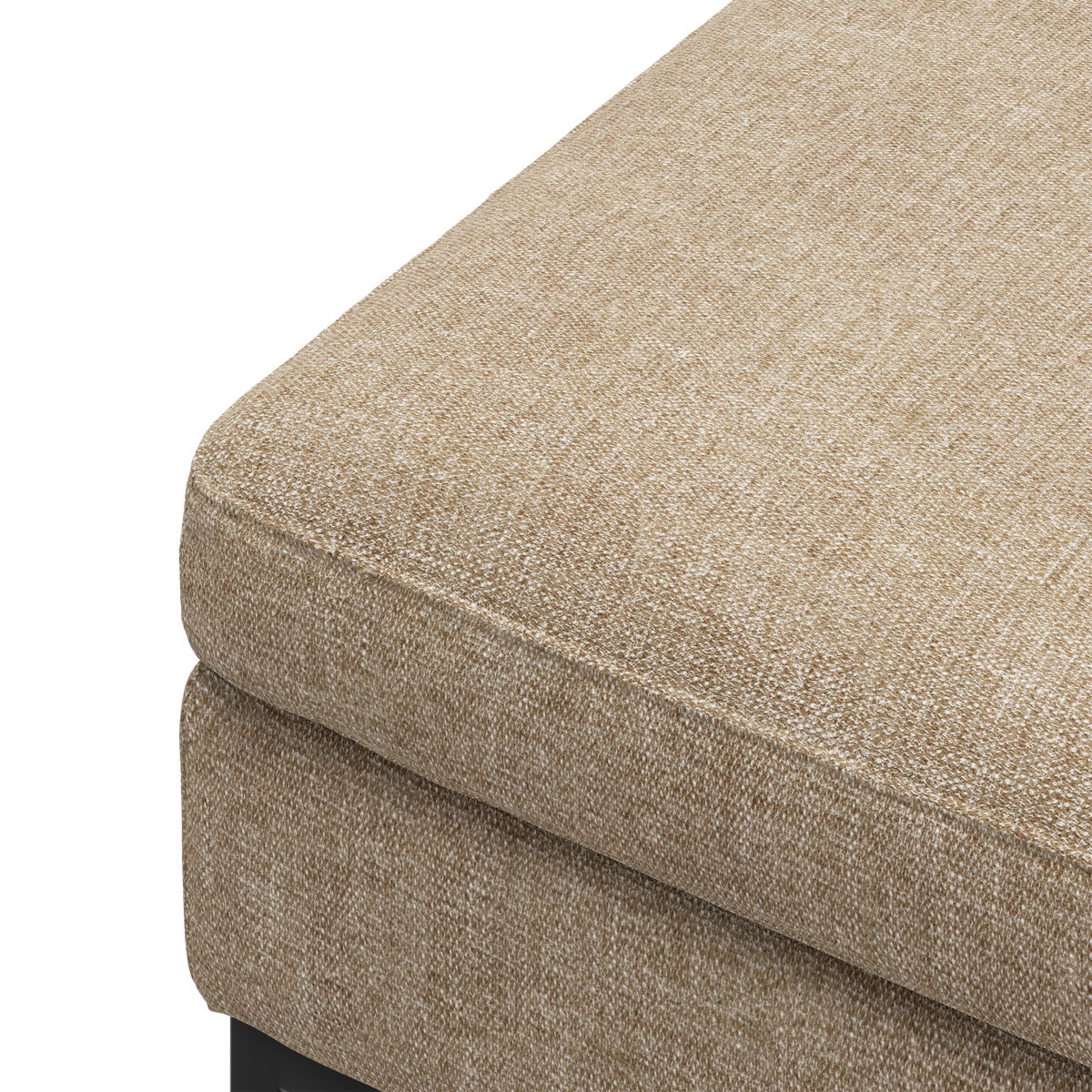 Nærbillede af et beige tekstilbetrukket sofa- eller ottomanhjørne med tyk siddepude.