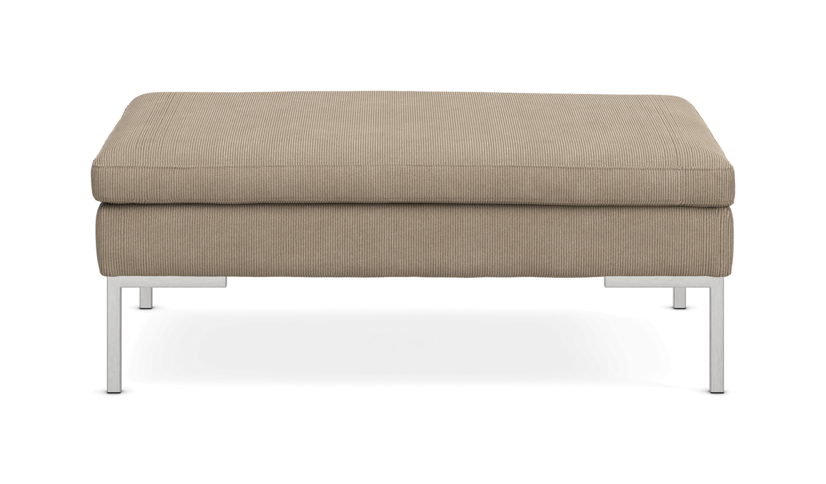 Beige puf i bred fløjl med metalben, set forfra.