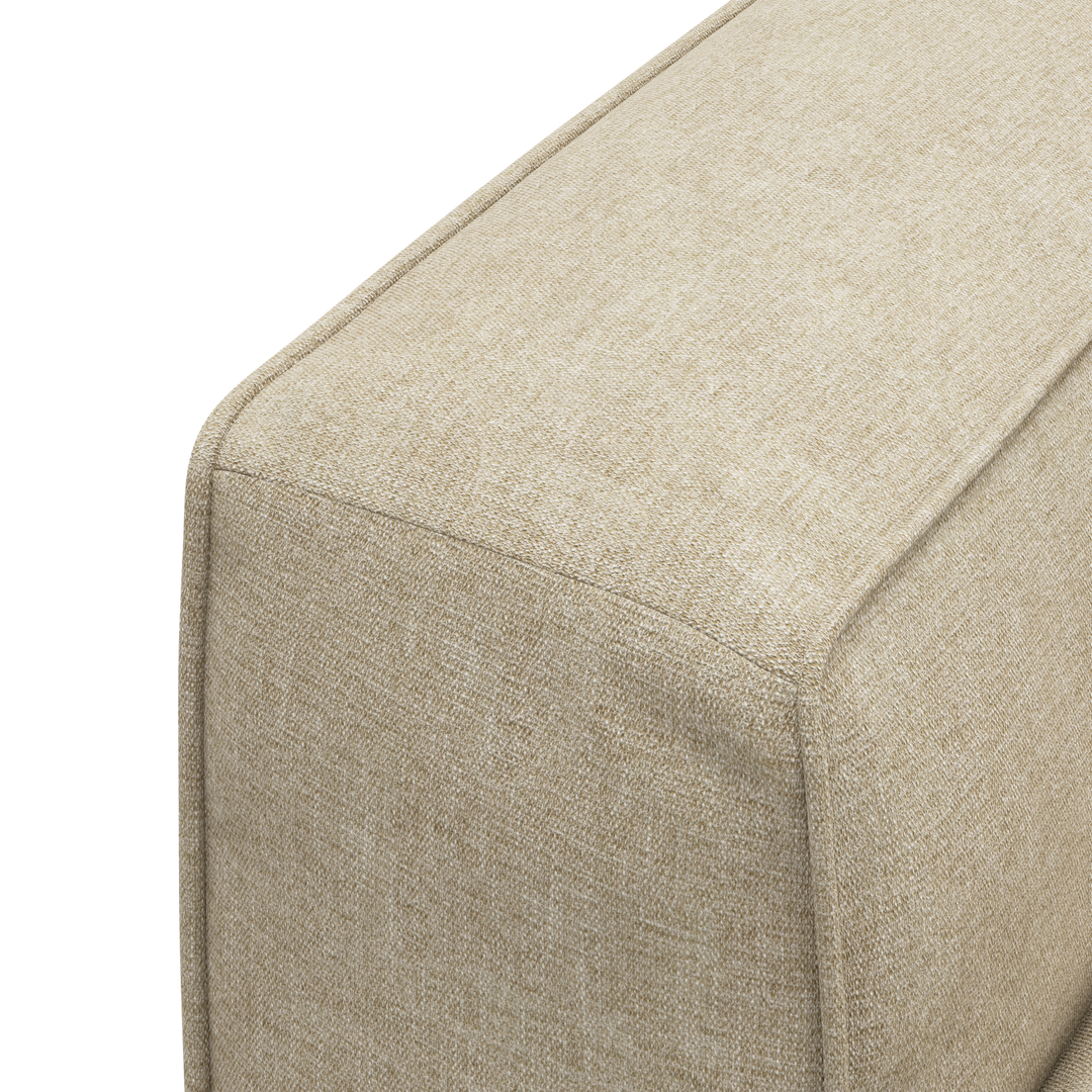 Nærbillede af beige tekstilbetrukket sofa-/pufmodul med tydelige syninger.