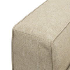 Nærbillede af beige tekstilbetrukket sofa-/pufmodul med tydelige syninger.