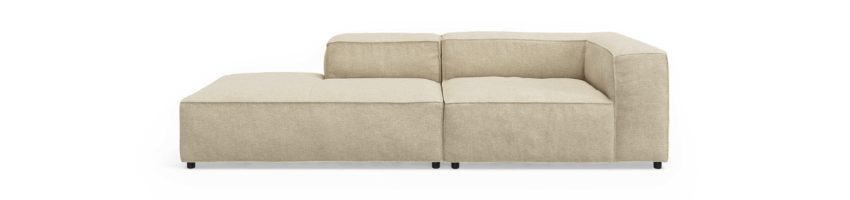 Beige modulsofa med venstre chaiselong, frontvisning mod sort baggrund.