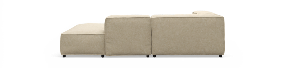 Beige modulsofa med venstrevendt chaiselong set bagfra, fritlagt produktbillede.