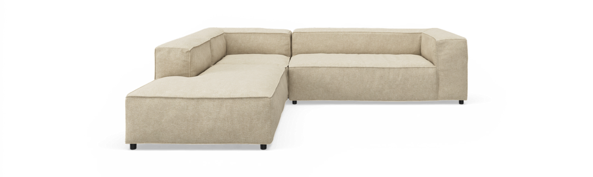 Beige L‑formet modulsofa med lave rygge på hvid baggrund.