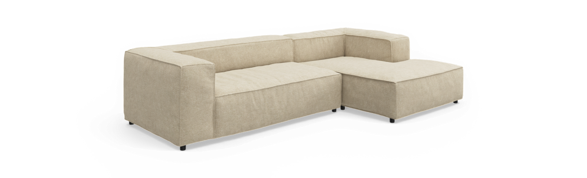 Beige L‑formet modulsofa med chaiselong til højre på frilagt baggrund.