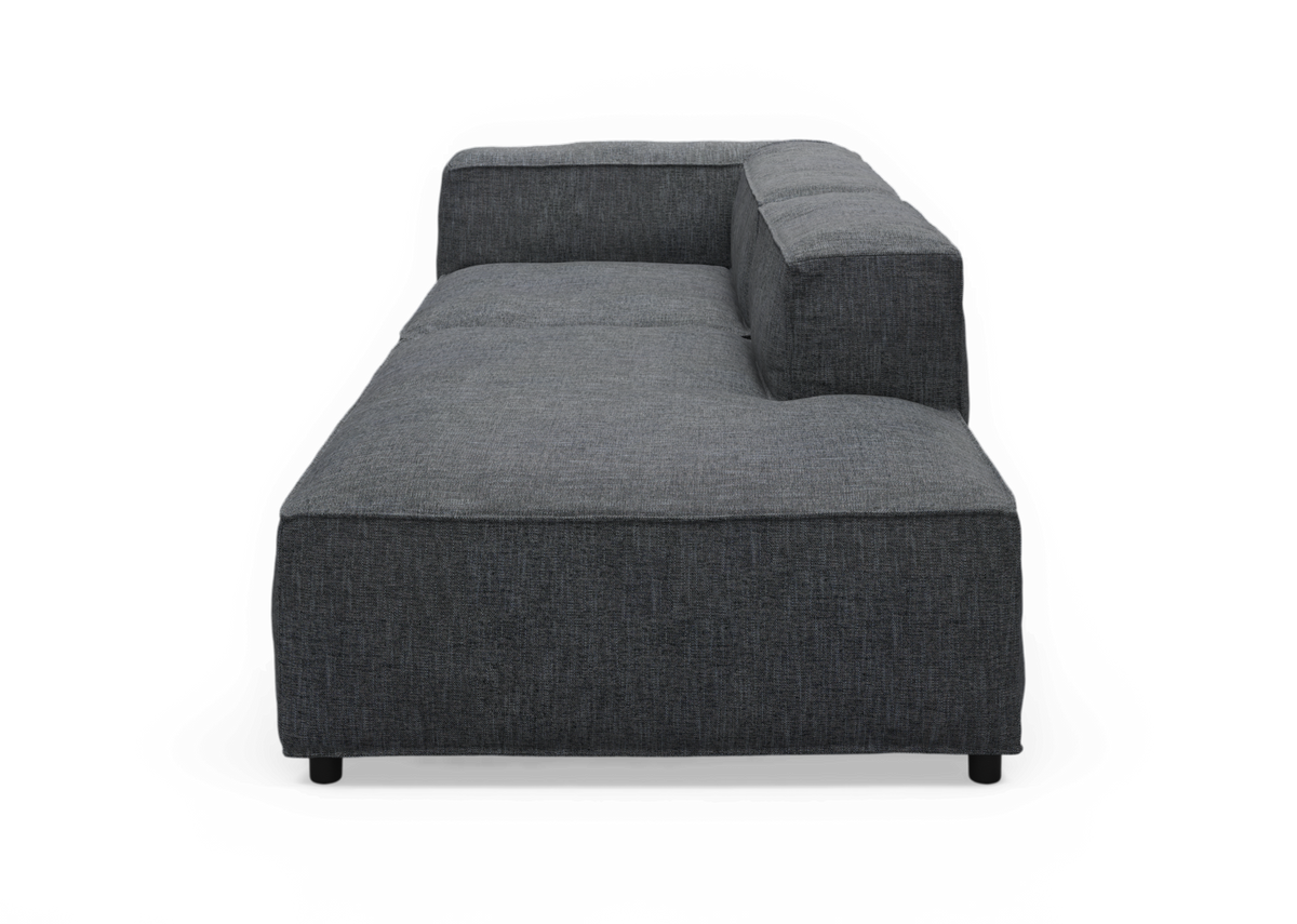 Mørkegrå modulsofa/chaise med høj ryg og højre armlæn, set forfra mod sort baggrund.