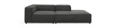 Mørkegrå L‑formet modulsofa med chaiselong til højre, frilagt mod sort baggrund, set forfra.