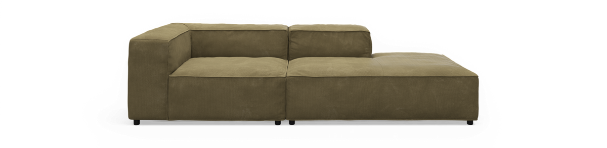 Lav modulsofa i olivgrøn fløjl med hjørne og chaiselong til højre, frilagt.