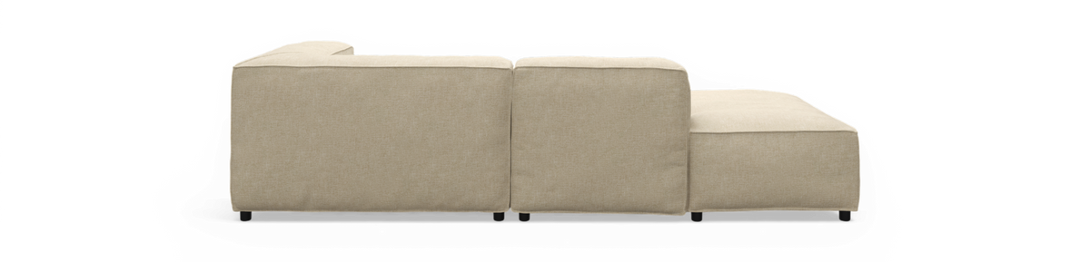 Beige modulsofa med chaiselong set fra siden, fritlagt.