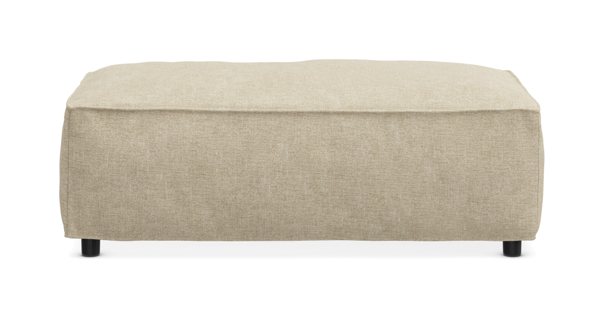 Beige rektangulær puf/ottoman i tekstil med små sorte ben, frilagt på hvid baggrund.