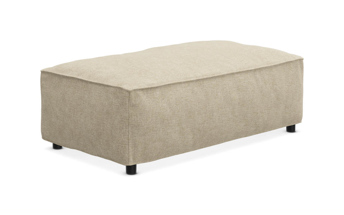 Beige rektangulær fodskammel/puf i stof med små sorte ben, frilagt på hvid baggrund.