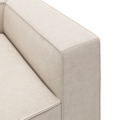 Nærbillede af beige stofsofas armlæn og sæde med enkel, minimalistisk form.