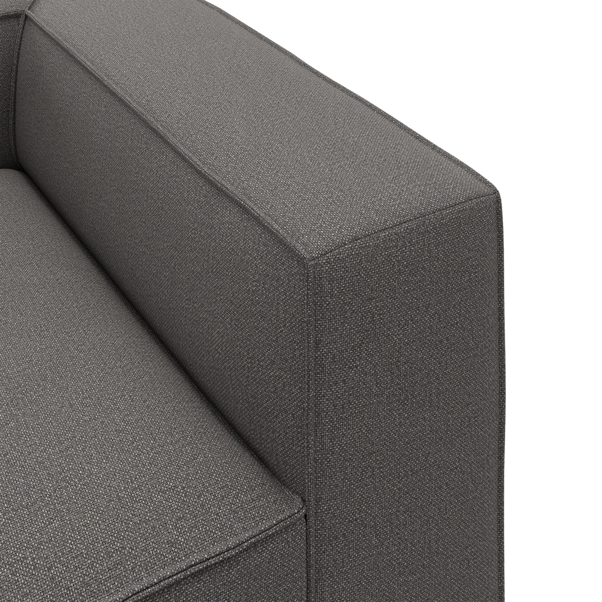 Nærbillede af grå stofsofa med kantet armlæn og sæde i minimalistisk, kasseformet design.