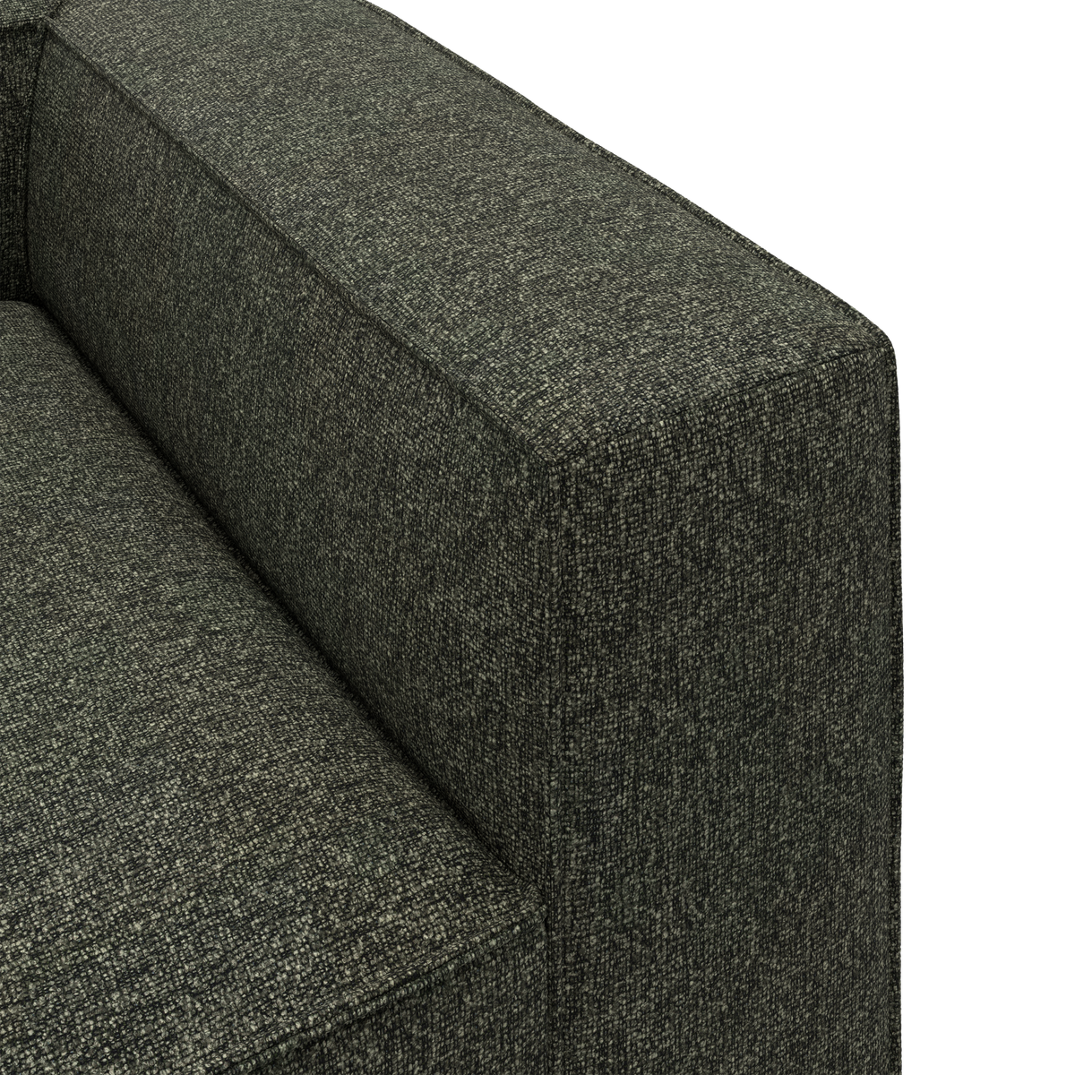 Nærbillede af armlænet på en mørkegrøn, tekstureret stofsofa med kantet, boxet design.