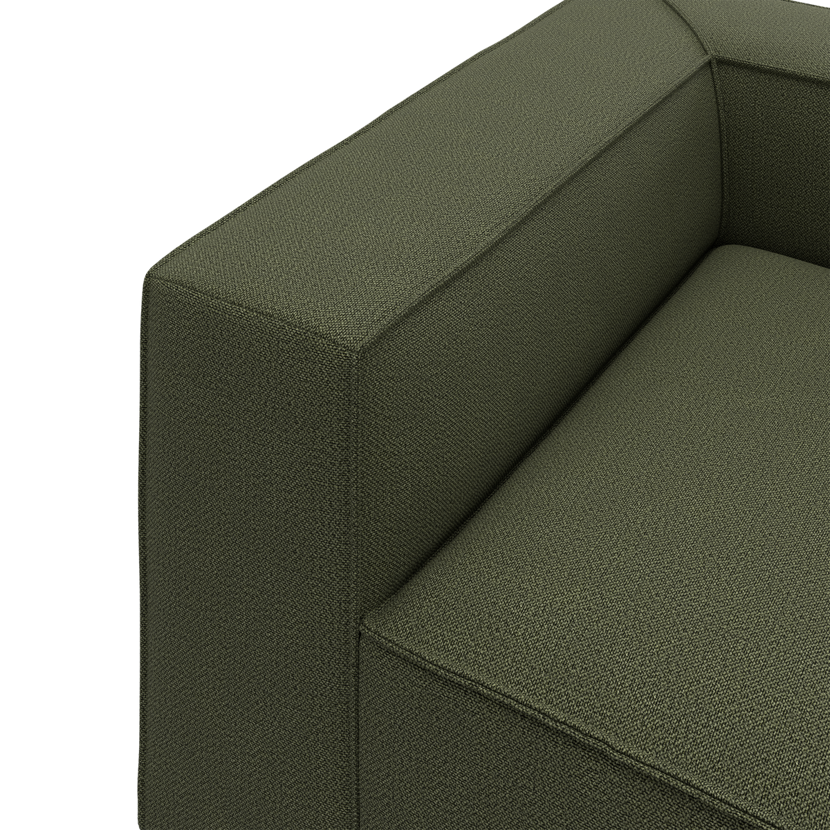 Nærbillede af en olivengrøn stofsofa med boxet armlæn og sæde i moderne design.