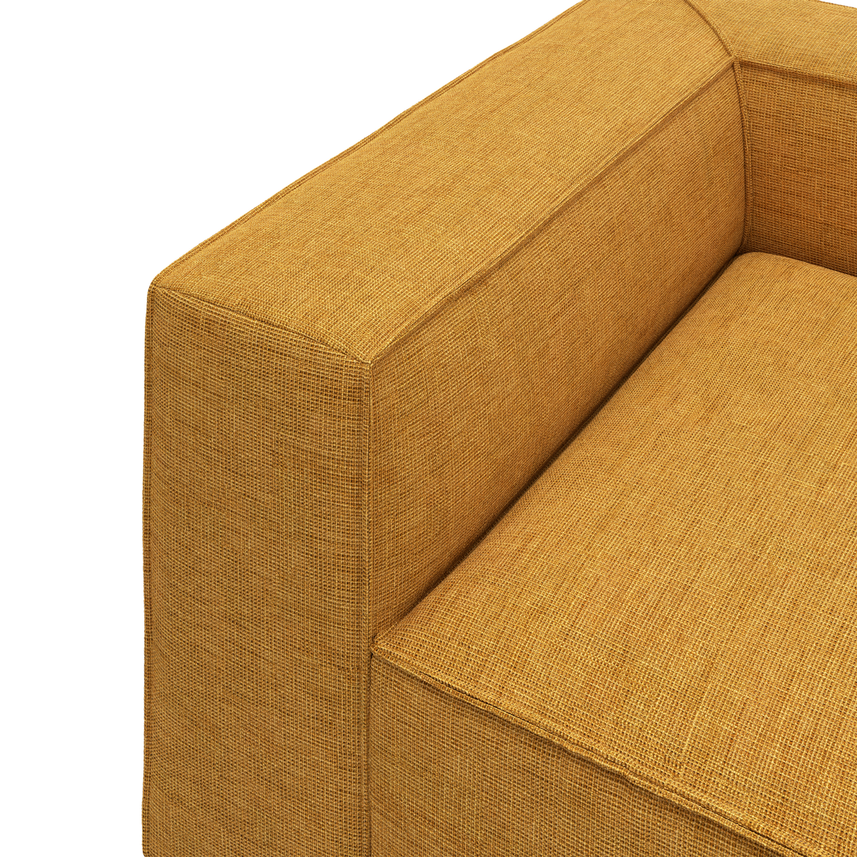Detalje af sennepsgul sofa med tekstureret stof og lige armlæn.